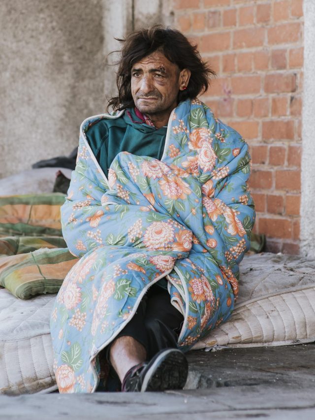 homeless-man-mattress-outdoors-blanket