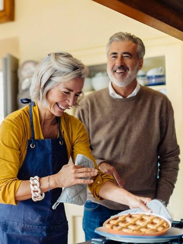 Mature couple laughing at joke in kitchen by sofie delauw - Stocksy United